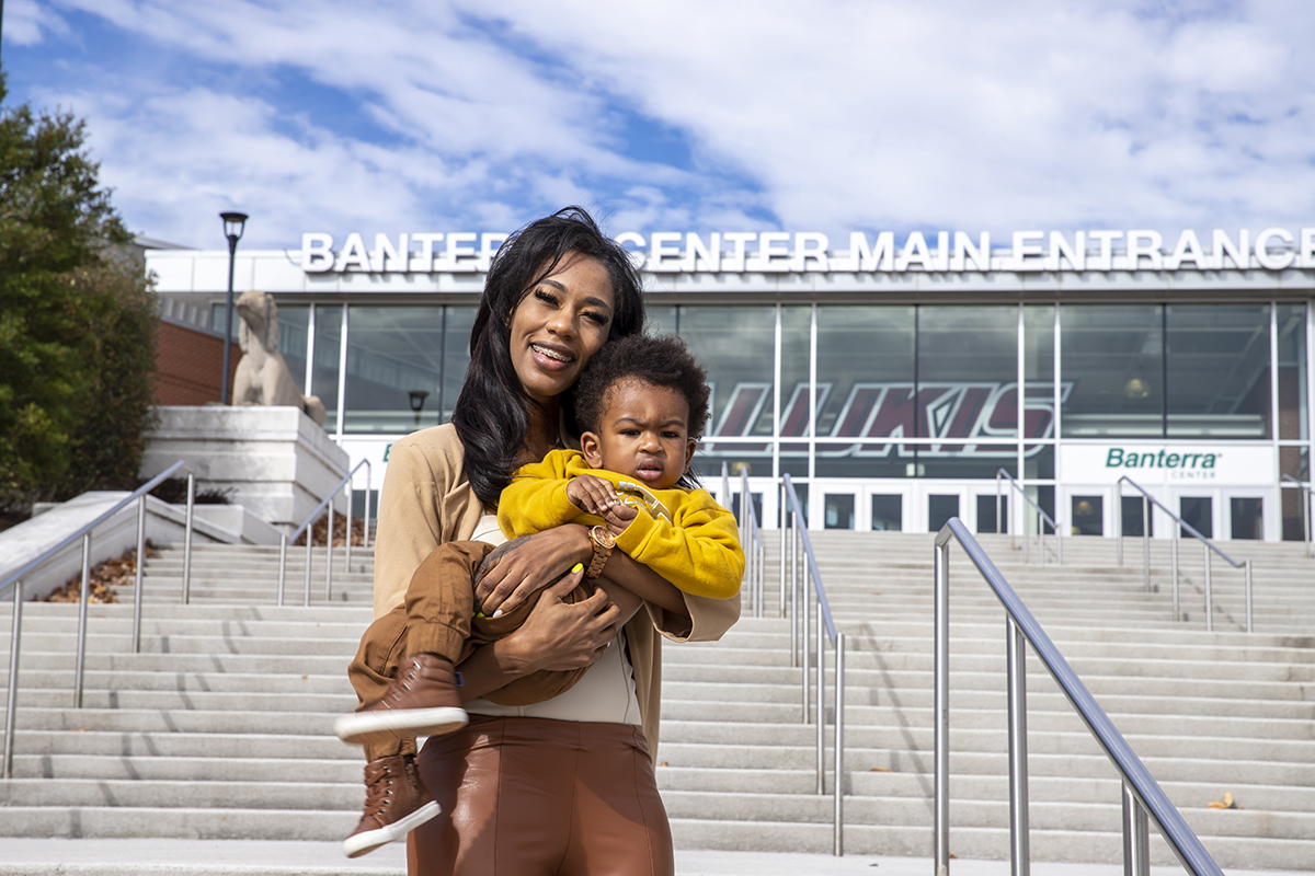 Kierra Greer holds her one-year-old son in front of the SIU Banterra Center.