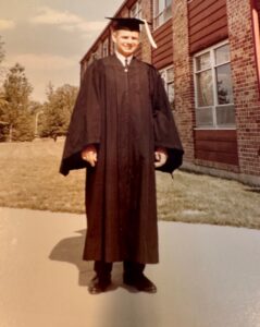 Vintage photo of Allan Hodges wearing his graduation cap and gown.