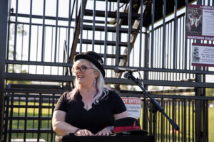 Lisa Breithaupt-Hanes speaks to the crowd during the dedication ceremony on Friday, Oct. 11. Sitting in front of her is her fathers Marching Salukis hat. 