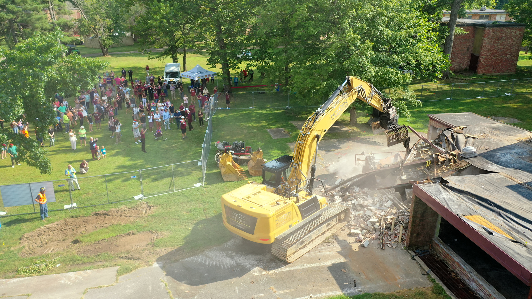 An excavator crashed through the roof of Fulkerson Hall, drawing cheers as the building’s first wall gave way.