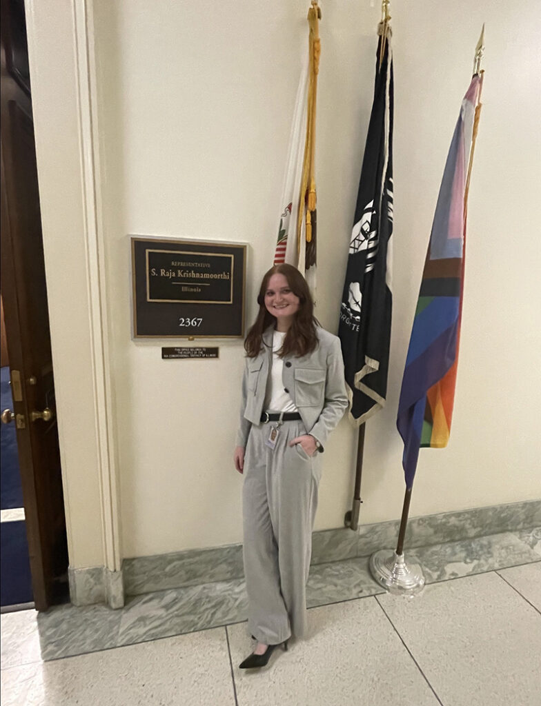 Anna Stearns poses outside the door of Raja Krishnamoorthi's office in Washington, D.C.