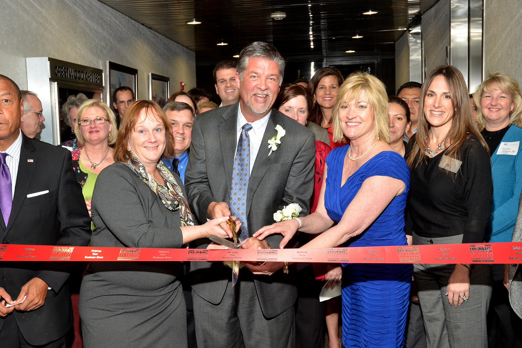 Dr. Mark Ashley and Susan Ashley cut a ribbon during the 2012 grand opening of the Centre for Neuro Skills San Francisco location, surrounded by employees and supporters gathered for the celebration.