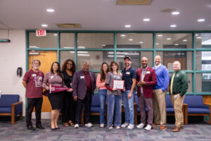 Michaela Hall, a mortuary science major from Durant High School in Plant City, Florida, stands with her parents, SIU Chancellor Austin A. Lane, SIU admissions staff and Durant High School leaders as she holds her Saluki Silver Scholarship certificate, valued at $2,500 per year; during the visit, Dr. Robert Morgan, dean of the SIU College of Health and Human Sciences, called to personally congratulate her and offer an additional $3,000 annual scholarship.