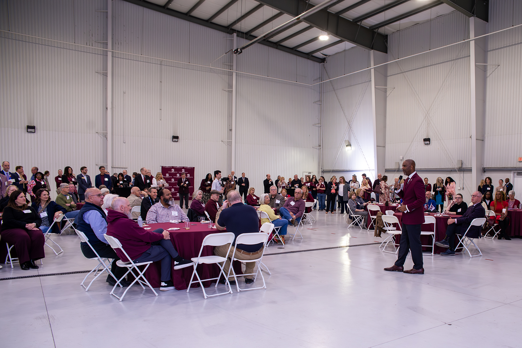 Chancellor Austin A. Lane speaks to a crowd of nearly 250 attendees seated at round tables and standing inside the LRS Hangar during the Saluki Takeover Tour Springfield Chancellor’s Reception.