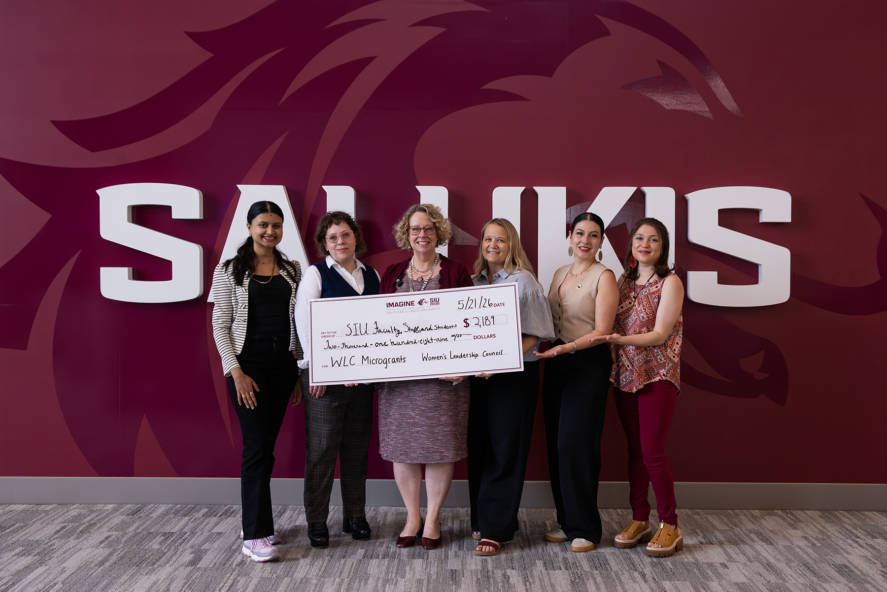 Recipients of the Women's Leadership Council micro-grant hold large check for photo.