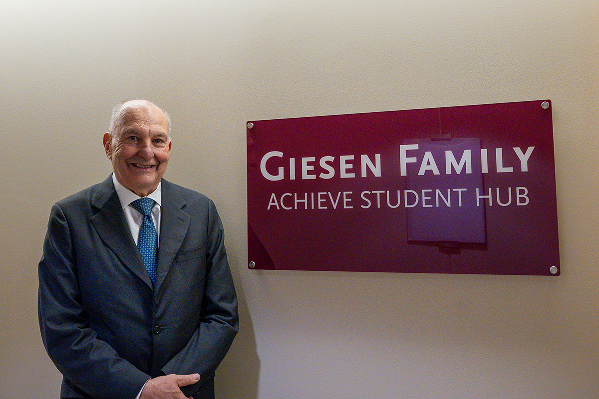 Dave Giesen stands beside the newly unveiled Giesen Family Achieve Student Hub sign at Southern Illinois University.